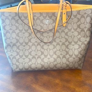 Reversible city tote purse with pouch included.